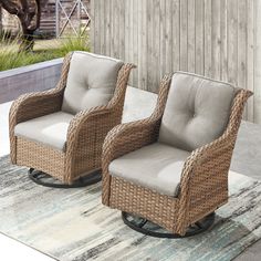 two wicker chairs sitting on top of a rug