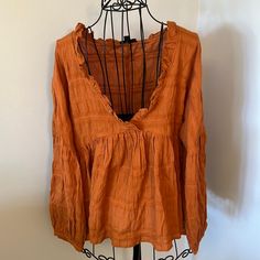 Lizard Thicket Mittoshop Long Sleeve Tunic With Ruffle Details Flowy Long-Sleeve Top Size: Small Color: Terracotta Material: 95% Cotton; 5% Spandex Smoke Free & Pet Free Home Bohemian V-neck Top With Ruffle Hem, Spring V-neck Peasant Top With Ruffles, Fall Peasant V-neck Top, Fall V-neck Top With Ruffle Hem, Long Sleeve Ruffled Top For Brunch, Chic Fall Cotton Peasant Top, Chic Long Sleeve Peasant Top For Brunch, Fall Peasant Style V-neck Top, Orange Long Sleeve Blouse With Ruffles