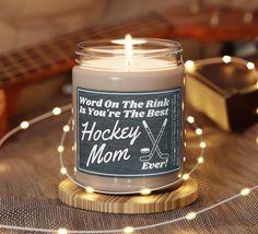 a candle is sitting on a table with some string lights around it and a guitar in the background