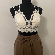 Stretchy Material Back With Removable Padding. This Comfortable Bralette Has Intricate Crochet Lace Details With Adjustable Stretchy Straps. You Can Easily Pair This With An Oversized Tank And Our Spider Biker Shorts. Www.Shopaprilbella.Com White Lace Crop Top With Built-in Bra, White Spaghetti Straps Crop Top With Lace Trim, White Camisole Bra With Lace Trim, White Lace Trim Camisole Bra, Spring Lace Beige Bra, Spring Beige Lace Bra, White Lace Camisole Crop Top, White Camisole Bra With Adjustable Straps, White Fitted Bra With Spaghetti Straps