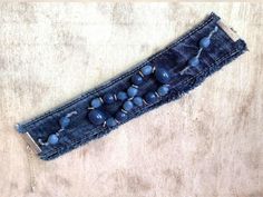 an old pair of jeans with beads on the bottom is laying on top of a table