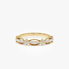 a yellow gold ring with three diamonds on the side and a thin band around it