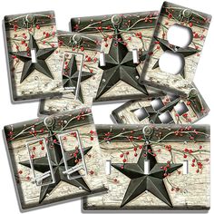 four black stars with red berries on them are hanging from a light switch plate cover