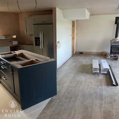 an empty kitchen is being remodeled with new cabinets and appliances on the counter top, and wood flooring has been stripped off