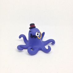 an octopus toy with a top hat on it's head is sitting in front of a white background