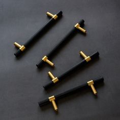 four black and gold colored swords on a table