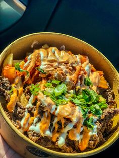 a bowl filled with meat, cheese and veggies on top of a table