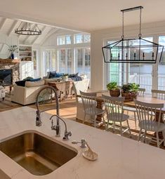 an open concept kitchen and living room with large windows overlooking the water is featured in this image