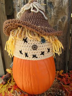 a crocheted pumpkin with a scarecrow's hat on top