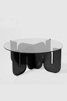 an oval glass table with black legs and two sections on each side, in front of a white background