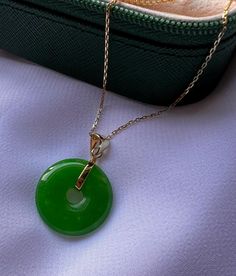 Embrace timeless elegance with this exquisite 14-carat gold-plated Jade round pendant necklace. The rich green  Jade gemstone is beautifully complemented by the luxurious gold plating, creating a piece that's both eye-catching and sophisticated. Perfect for any occasion, this necklace is designed to bring a touch of nature's beauty to your everyday wardrobe. Whether you're looking to elevate your own style or searching for the perfect gift, this necklace is a stunning choice. Crafted for durability and comfort, it's an affordable way to add a touch of luxury to your jewelry collection. Features: *14K gold-plated chain and setting for a luxurious look. * Jade gemstone with a classic round pendant design. *Versatile piece, ideal for layering or wearing alone.  *Perfect for gifting or treatin Luxury Oval Pendant Jade Necklace, Green Jewelry For Good Luck, May Birthstone, Elegant Jade Round Pendant Jewelry, Elegant Jade Necklace Round Shape, Elegant Jade Round Necklace, Elegant Round Jade Necklace, Green Gemstone Necklace For Good Luck, Jade Gemstone Round Pendant Necklace, Green Gemstone Round Pendant Necklace