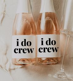 two bottles of i do crew wine next to a glass filled with pink liquid on a white surface