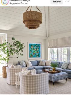 a living room filled with furniture and a painting on the wall above it's windows