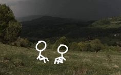 two stick figures are standing in the grass