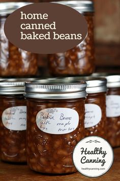 jars filled with baked beans sitting on top of a wooden table next to a label that says home canned baked beans