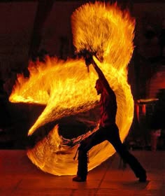 a man is dancing with fire in the dark