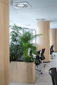 an office with wooden planters and black chairs