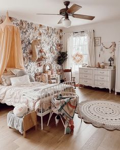 a bed room with a neatly made bed next to a window and a ceiling fan