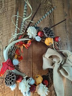 an autumn wreath with acorns, pine cones and leaves on a wooden surface