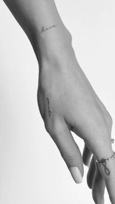 a woman's hand with a small tattoo on it