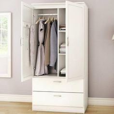 an open closet with clothes hanging on the door and two drawers in front of it