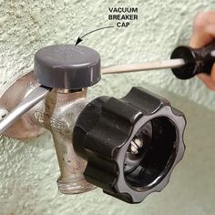 a person fixing a water heater with a wrench and screwdriver on the wall