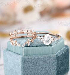 two wedding rings sitting on top of a blue box