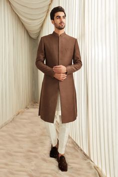 Coffee sherwani in a silk base with welt pocket in front, mandarin collar and full length sleeves. Comes with ivory straight pants.
Component: 2
Neckline: Mandarin Collar
Sleeve Type: Full
Fabric: Silk
Color: Brown
Other Details: 
Welt pocket in front
Sherwani with side slits
Note: Inner kurta worn by the model is not for sale
Occasion: Wedding - Aza Fashions Formal Long Sleeve Brown Kurta, Elegant Long Sleeve Brown Kurta, Formal Brown Kurta For Eid, Elegant Brown Kurta With Dabka Detailing, Elegant Brown Kurta With Dabka Embroidery, Elegant Brown Kurta With Dabka, Classic Long Sleeve Sherwani With Naqshi, Classic Long Sleeve Sherwani For Eid, Formal Brown Festive Kurta