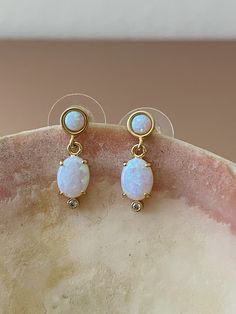 "Opal Earrings, Opal Drop Earrings, Gold Opal Earrings, October Birthstone, October Earrings, Birthstone Earrings, Opal Jewelry, Opals, Opal Beautiful flashy & dainty Opal drop earrings that will add a little glam to your everyday! DETAILS: * 14KT gold over brass * Nickel free * Synthetic Opal + Cubic Zirconia stones * Length: .75\" (17mm) Let's connect! Instagram: @mysticajewelry Facebook: @mysticajewelry Website: mysticajewelry.com All of our jewelry is designed and hand made with love in our White Opal Earrings For Pierced Ears, White Opal Drop Earrings, Oval Stone Earrings Gift, Oval Stone Earrings For Gift, October Earrings, Opal Drop Earrings, Drop Earrings Gold, Birthstone Earrings, Synthetic Opal