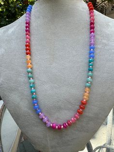 Embrace the vibrant energy of the rainbow with the Rainbow Radiance Chakra Necklace. This eye-catching piece features a gradient of colorful beads, each corresponding to one of the seven chakras. Designed to balance your energy centers, this necklace is not only a beautiful accessory but also a powerful tool for spiritual alignment and healing. Wear it to infuse your day with positivity and harmony. Materials: Mixed gemstones (Amethyst, Carnelian, Aventurine, and more) Length: 20 inches Closure: Toggle clasp Rainbow Round Beads Necklace For Healing, Adjustable Rainbow Crystal Necklace With Faceted Beads, Iridescent Adjustable Necklace With Round Beads, Iridescent Adjustable Round Bead Necklaces, Multicolor Single Strand Necklace For Festival, Rainbow Gemstone Beaded Necklaces For Gift, Rainbow Gemstone Beaded Necklaces As A Gift, Adjustable Rainbow Polished Beads Necklace, Rainbow Spiritual Necklace For Meditation