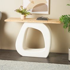 a white table with a plant on it in a living room next to a chair