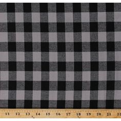 a black and white checkered fabric with a ruler in the foreground, it is very