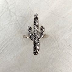 "Listing for one ring. Saguaro cactus ring, hand carved design, cast in the Heliotrope studio. Choose solid sterling silver ($54), or solid brass ($44) at checkout. Select your size at checkout. Saguaro measures approximately 1.25\" tall x .5\" wide. Check out our other listings for MATCHING earrings and necklace: https://www.etsy.com/listing/579322655/spiny-saguaro-necklace-silver-or-brass? https://www.etsy.com/listing/552978260/spiny-saguaro-studs-cactus-earrings?ref=shop_home_feat_4" Rustic Adjustable Etched Jewelry, Southwestern Style Engraved Rings As Gifts, Southwestern Style Engraved Rings For Gifts, Southwestern Style Engraved Ring As Gift, Southwestern Style Engraved Gift Ring, Southwestern Etched Jewelry For Gifts, Cactus Ring, Cactus Earrings, Hammered Band