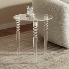 a clear glass table sitting on top of a rug