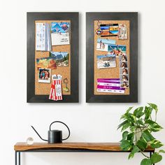 two black framed pictures hanging on a wall next to a wooden table with a potted plant