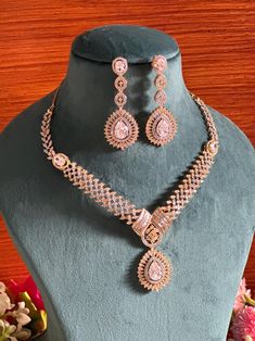 Add a touch of elegance and sophistication with this gold and silver finish necklace set in beautiful clear stones. The stones in this set bling and look close to the real thing. This set is sure to make heads turn!  It features an adjustable necklace and a pair of earrings. It can be paired perfectly with both ethnic and western outfits.  In case of any queries, please feel free to reach out. Happy shopping!   Length: 16 inches with an adjustable high quality metal chain at the back Earrings length: 2 inches Each earring weighs 10 gms  Closure: Pushback Silver Gold-plated Bridal Sets For Party, Cubic Zirconia Jewelry Sets With Stone Setting For Party, Silver Cubic Zirconia Jewelry Sets With Stone Setting, Silver Gold-plated Bridal Sets With Elegant Design, Dazzling Cubic Zirconia Jewelry Sets With Stone Setting, Elegant Stone-set Jewelry For Wedding, Silver American Diamond Jewelry Sets With Stone Setting, Gold Bridal Sets With Hand Set Crystals, Dazzling Cubic Zirconia Jewelry Set