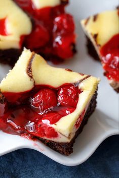 several pieces of cheesecake with cherries on top are sitting on a white plate