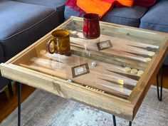 a coffee table with two cups on it and a game board in the middle,