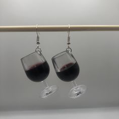 two wine glasses hanging from a wooden bar with silver earwires and dangling earrings