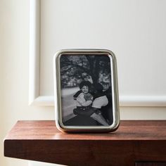 a photo frame sitting on top of a wooden table