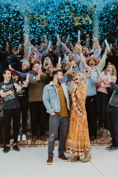 a group of people standing next to each other with confetti in the air