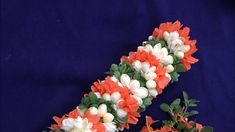 an orange and white flower garland on a blue background