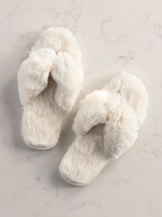 Step into comfort in Shiraleah’s Rina Slippers. This slipper features a plush texture upon a rubber bottom making them cozy, yet sturdy. The Rina slipper has an open toe thong silhouette , fulfilling your style aspirations without compromising your need for comfort. Packaged ribbon wrapped, this item makes a great gift option in addition to completing your nighttime solace. Pair with other items from Shiraleah to complete the look! Color: Ivory S/M Fits Size 6-8 Material: Polyester And Pvc Made Comfy Cream Slippers With Soft Detail, Cream Colored Comfy Slippers With Soft Detailing, Comfy Soft Cream Slippers, Comfy Cream Soft Slippers, Cream Soft Comfy Slippers, Comfy White Slippers With Soft Texture, Comfortable Soft Slippers For Beach, Comfortable Fluffy White Slippers, Soft White Slippers For Relaxation