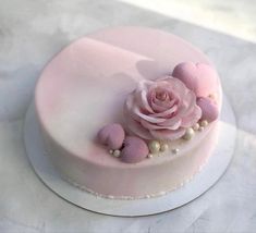 there is a pink cake with flowers on it