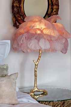 a pink lamp sitting on top of a table next to a mirror