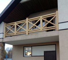 a dog is standing on the balcony of a house that has been painted white and brown