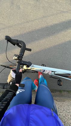 someone is sitting on the ground with their feet propped up next to a bike tire