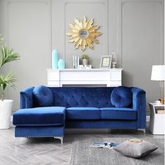 a blue couch sitting in front of a white table with a gold sun decoration on it