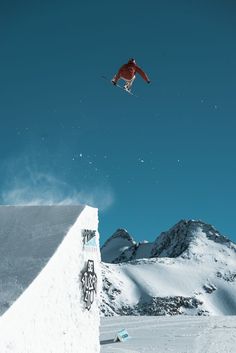 a man flying through the air while riding a snowboard