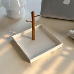 a white tray with a wooden cross on it and an apple in the back ground